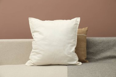 Kahverengi arka planda rahat koltukta boş yumuşak yastık.