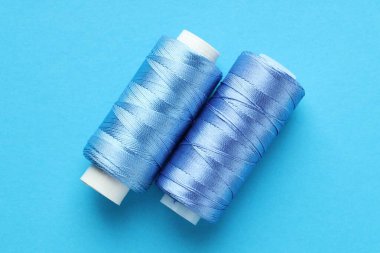 Açık mavi arkaplanda dikiş iplikleri, üst görünüm