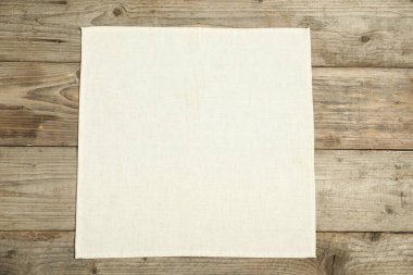 Ahşap masanın üstünde ışık peçetesi, üst manzara.