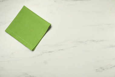 Beyaz mermer masada yeşil peçete, üst manzara. Metin için boşluk