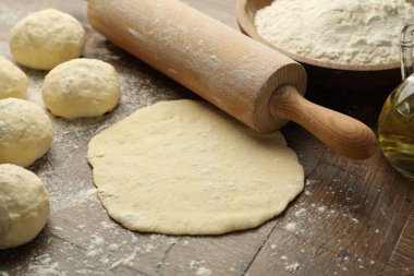 Taze hamur, merdane, un ve yağ ahşap masada, yakın plan.