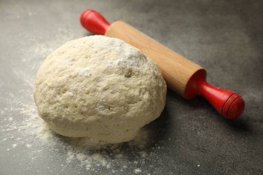 Taze hamur ve merdane gri masada, yakın plan.