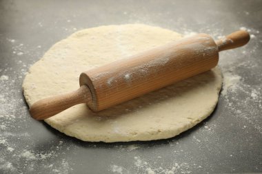 Taze hamur ve merdane gri masada, yakın plan.