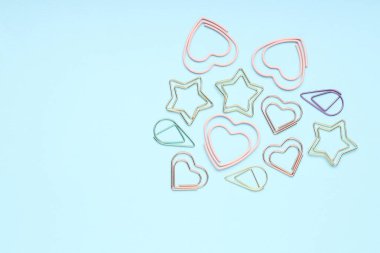 Açık mavi arka planda farklı ataçlar, düz yatış. Metin için boşluk