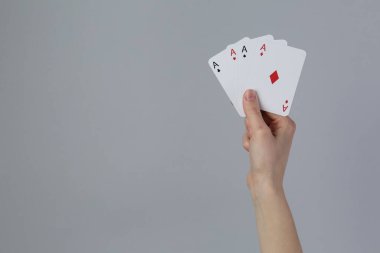 Gri arka planda iskambil oynayan kadın, yakın plan. Metin için boşluk