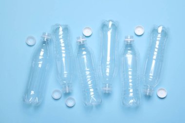 Açık mavi zemin üzerinde boş plastik şişeler, düz yatıyordu