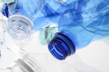Kırışmış plastik şişeler beyaz arka planda, yakın plan.