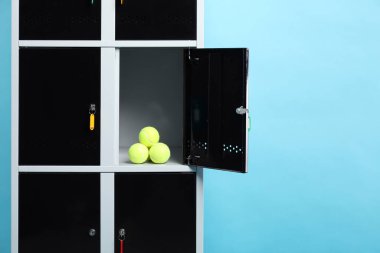 Açık mavi arka planda tenis toplarıyla açık dolap, metin için boşluk