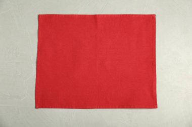 Açık gri masada kırmızı peçete, üst manzara.