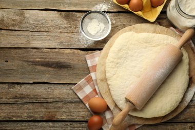 Taze hamur, merdane, un, yumurta ve ahşap masa üzerinde fırça, düz yatak. Metin için boşluk