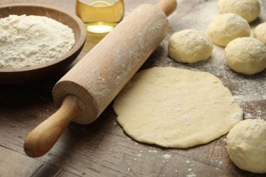 Taze hamur, merdane, un ve yağ ahşap masada, yakın plan.