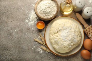 Taze hamur, malzemeler ve gri masa üzerinde merdane, düz. Metin için boşluk