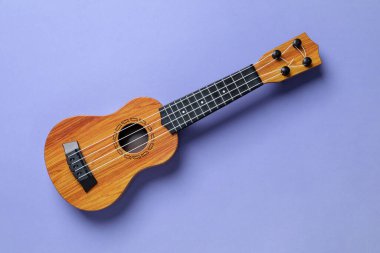 Menekşe arkaplanda bir ukulele, üst görünüm