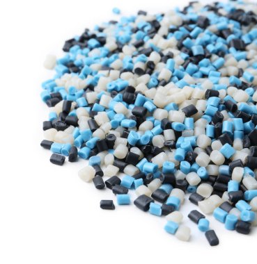 Beyaz arkaplanda renkli plastik granüller yığını