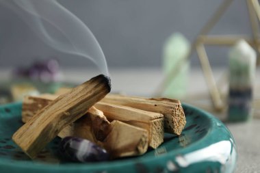 Yanan palo santo sopası ve değerli taş masanın üstünde, yakın plan.
