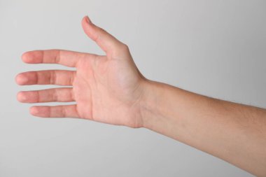 Açık gri arkaplanda görünür el damarları olan kadın, yakın plan.