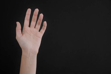 Siyah arka planda görünen el damarları olan kadın, yakın plan. Metin için boşluk