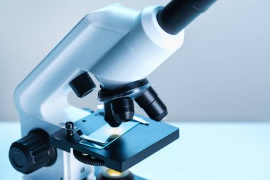 - Bilim. Bulanık arka planda cam kaydıraklı mikroskop, yakın plan. Metin için boşluk