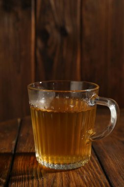 Ahşap masada fincanda yeşil çay, yakın plan.