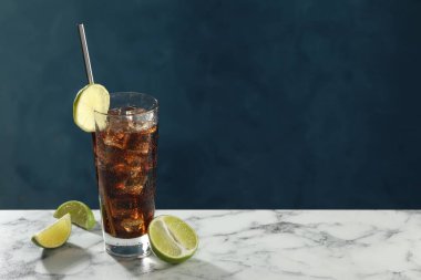 Mavi arka planda beyaz mermer masada limon dilimleri ile buzlu kolayı tazeliyorum. Metin için boşluk