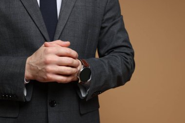 Kahverengi arka planda klasik takım elbiseli adam, yakın plan. Metin için boşluk