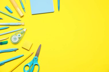 Sarı arka planda farklı kırtasiye malzemesi, düz. Metin için boşluk