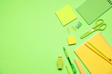 Yeşil arka planda farklı kırtasiye malzemesi, düz. Metin için boşluk