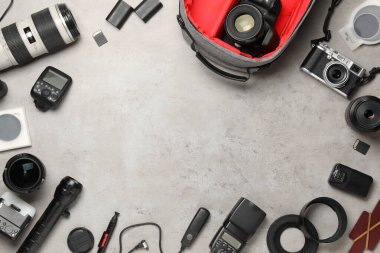 Profesyonel fotoğrafçı ekipmanı ve arka planda sırt çantası, düz yatış. Metin için boşluk