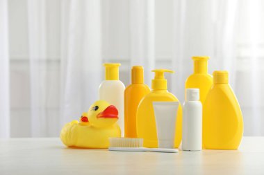 Bebek kozmetik ürünleri, fırça ve lastik ördekler açık ahşap masa içinde. Metin için boşluk