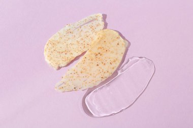 Açık mor arka planda kozmetik ürünleri örnekleri, üst görünüm. Cilt bakımı