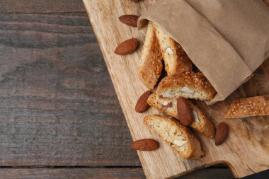 Lezzetli bademli bisküviler (Cantuccini) ve ahşap masada fındıklar, üst manzara. Metin için boşluk