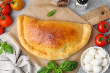 Lezzetli vejetaryen calzone, domatesli, mozzarella peynirli ve fesleğenli gri masa, üst manzara