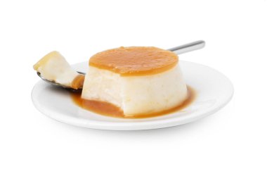 Karamel soslu lezzetli puding ve beyaz üzerine izole edilmiş kaşık.