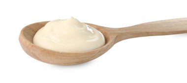 Tahta kaşıkta mayonez sosu. Beyaz kaşıkta izole edilmiş.