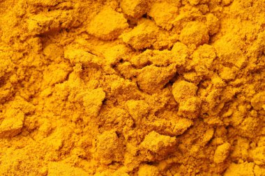 Aromatic turmeric powder as background, top view