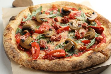 Mantarlı, domatesli ve roka soslu lezzetli pizza, yakın plan.