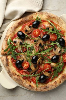 Mantarlı lezzetli pizza, zeytin ve roka açık gri masa, üst manzara.