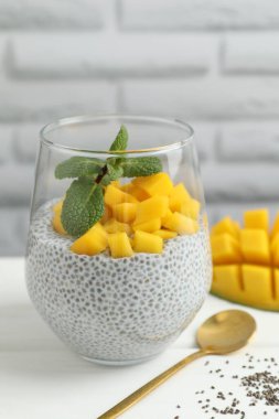 Mangolu lezzetli chia pudingi ve beyaz masada nane şekeri.