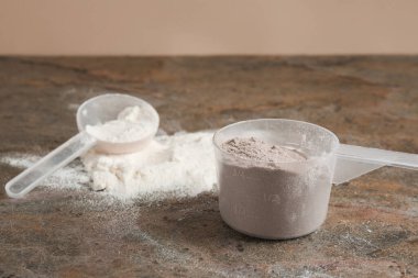 Gri desenli masadaki protein tozları ve kepçeler