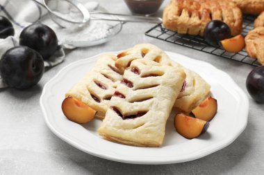 Gri masada lezzetli puf börekleri ve erikler, yakın plan.