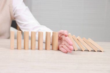 Masada tahta blokların düşmesini engelleyen kadın, yakın plan. Domino etkisi