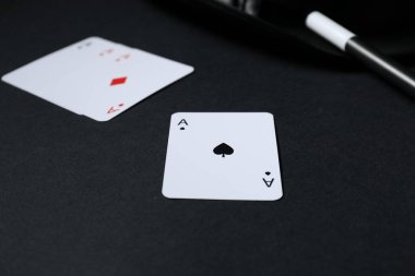 Oyun kartları, şapka ve sihirli değnek siyah arka planda, yakın plan
