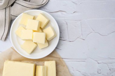 Beyaz desenli masa üzerinde taze tereyağı parçaları, üst manzara. Metin için boşluk