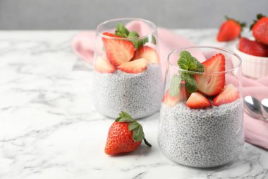 Çilekli lezzetli chia pudingi ve beyaz mermer masada nane şekeri, yakın plan. Metin için boşluk