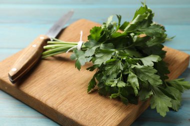 Taze maydanoz, bıçak ve tahta kesme tahtası mavi ahşap masa, yakın plan