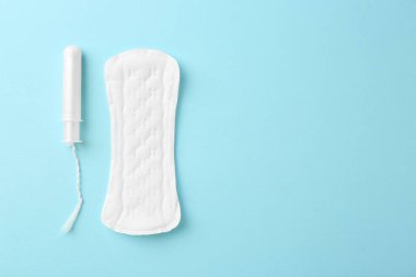 Açık mavi arka planda regl pedi ve tampon, üst manzara. Metin için boşluk