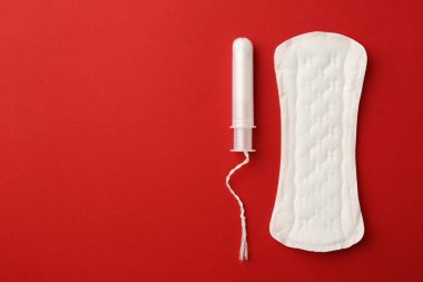 Kırmızı arka planda regl pedi ve tampon, üst manzara. Metin için boşluk