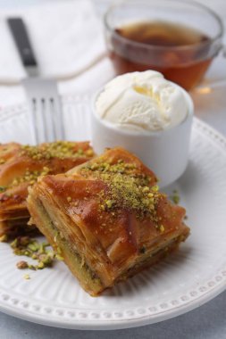 Gri masada ezilmiş fındıklı ve dondurmalı enfes baklava, yakın plan.