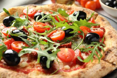 Domatesli, zeytinli ve roka soslu lezzetli pizza.