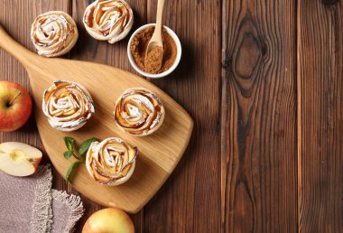 Tahta masada servis edilen pudra şekerli elma gülleri. Metin için boşluk